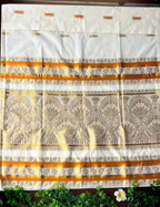 House Of Paramya off-white cotton Kasavu saree featuring golden lotus jacquard patterns and a vibrant orange border.