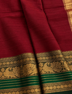 House Of Paramya maroon Chettinad cotton saree with a bottle green border featuring antique gold zari peacock motifs.