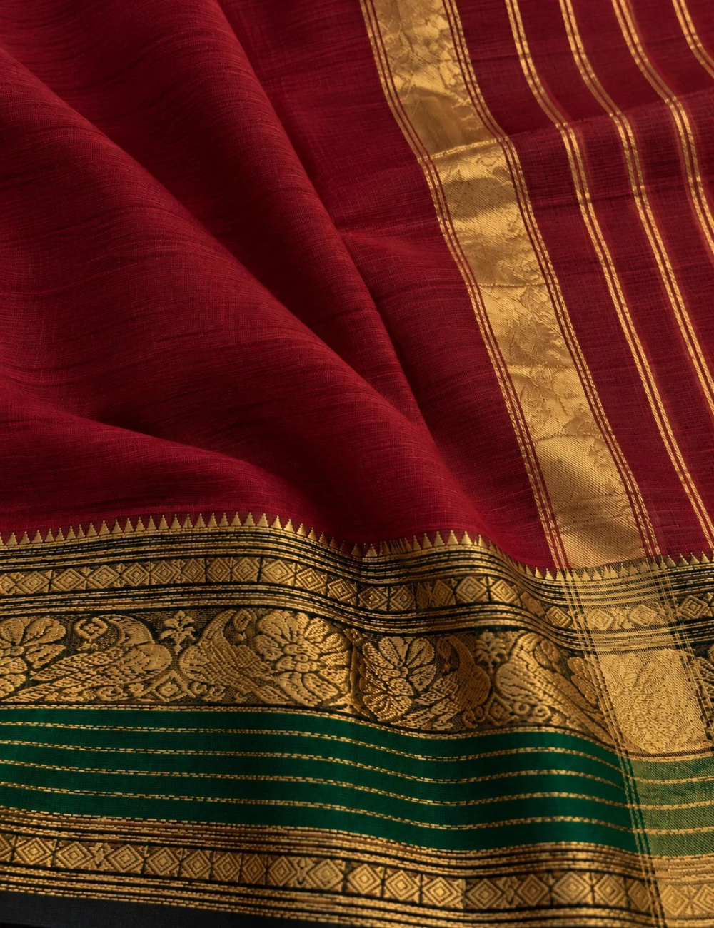 House Of Paramya maroon Chettinad cotton saree with a bottle green border featuring antique gold zari peacock motifs.
