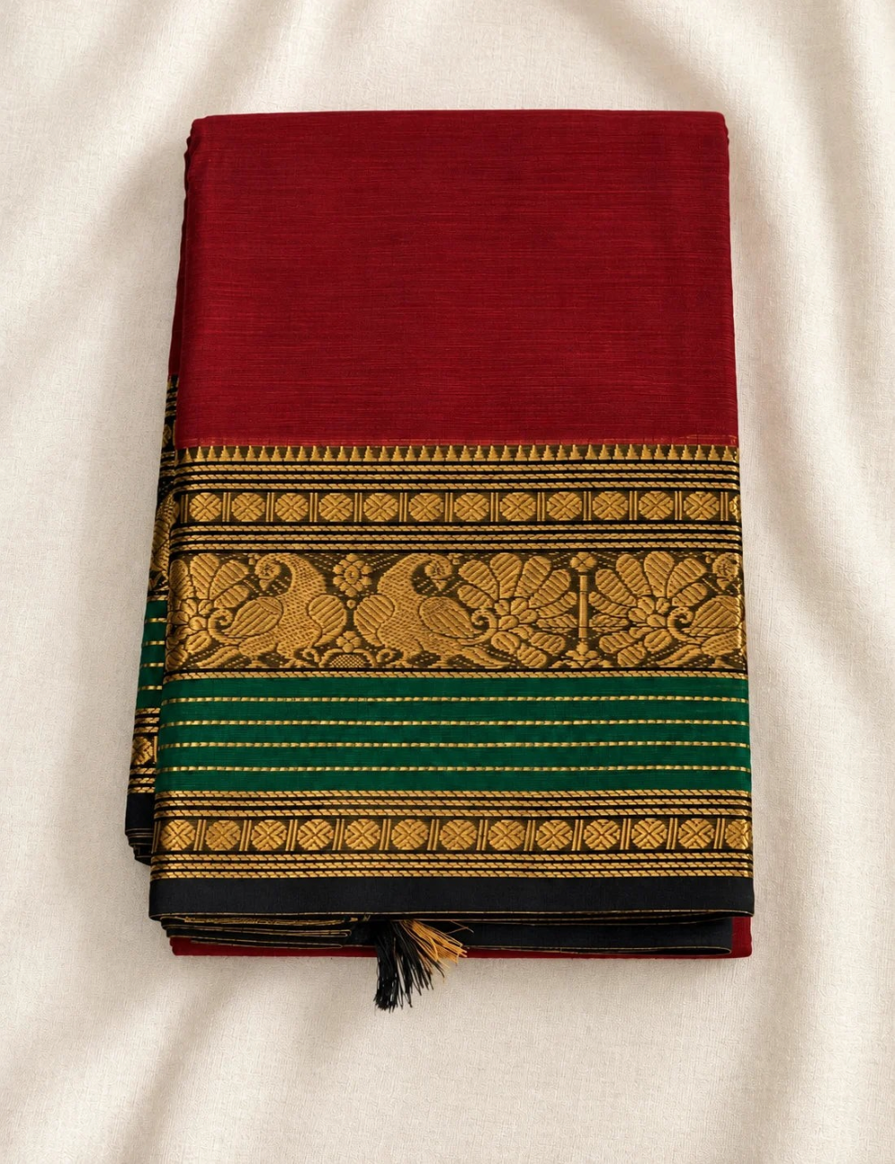 House Of Paramya maroon Chettinad cotton saree with a bottle green border featuring antique gold zari peacock motifs.