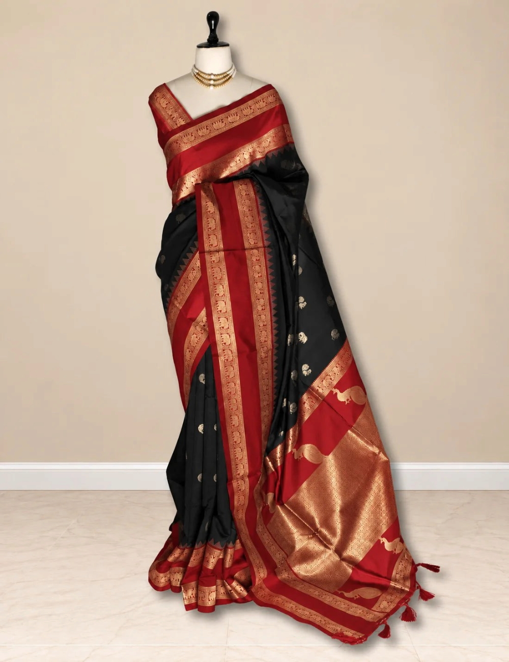 House Of Paramya black and red semi soft silk saree with gold zari elephant border and peacock pallu on a mannequin