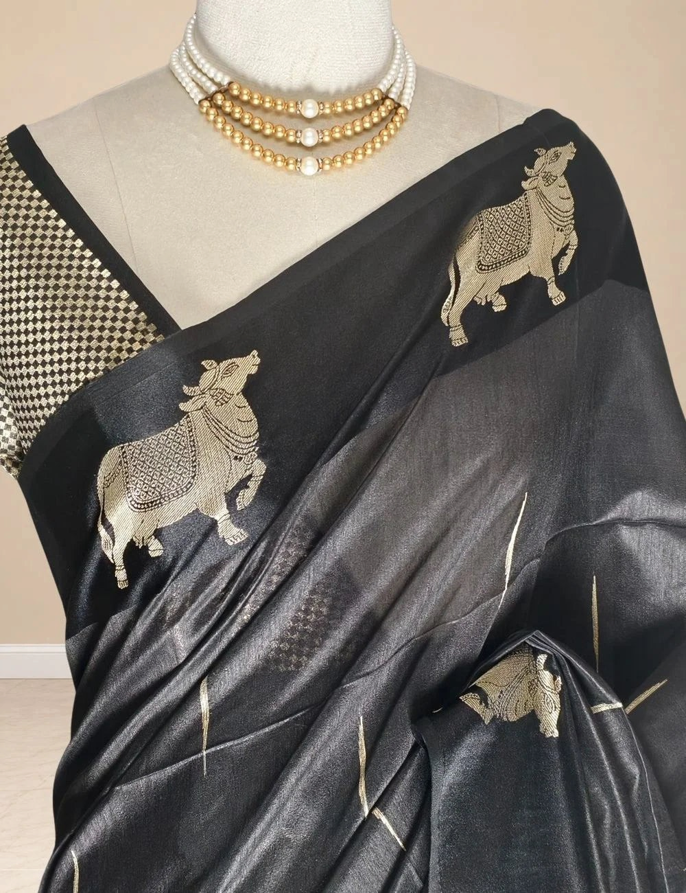 House Of Paramya black raw tussar silk saree featuring intricate gold zari Pichwai cow motifs on a mannequin