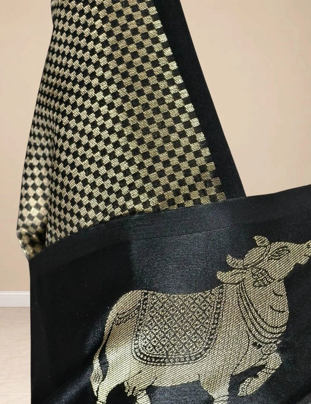 House Of Paramya black raw tussar silk saree featuring woven gold zari Pichwai cow motifs and a checkered pallu.