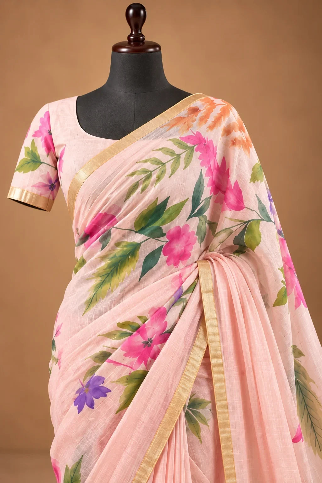 House Of Paramya blush pink linen saree with watercolor floral print, green vines, and gold border on a mannequin.