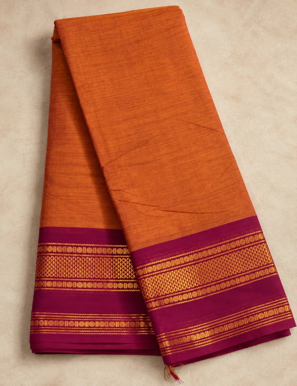 House Of Paramya burnt orange Chettinad cotton saree with a maroon border featuring intricate gold zari rosette motifs.