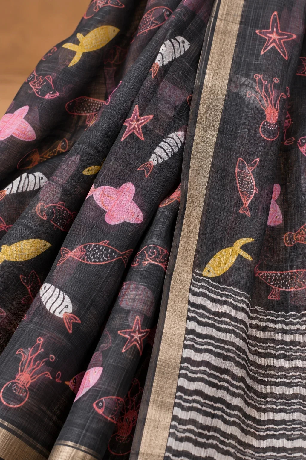 House Of Paramya charcoal linen saree with whimsical marine print of fish and starfish, featuring a chevron pallu.