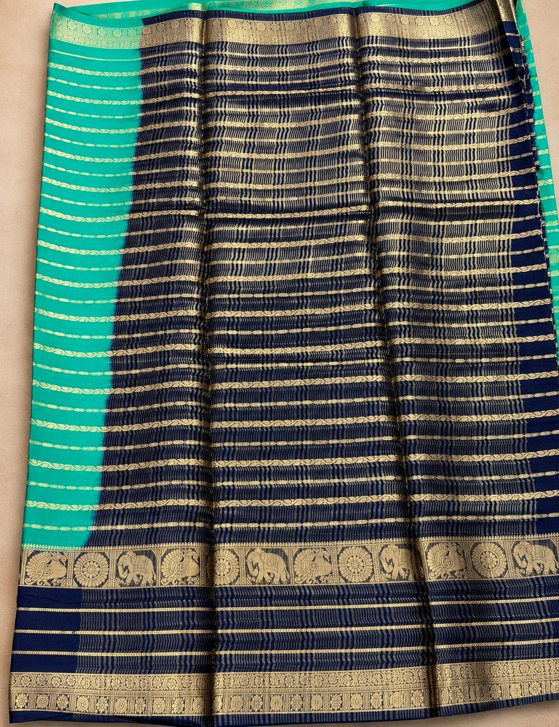 House Of Paramya crepe silk saree featuring navy blue and turquoise green stripes with gold elephant motif borders.
