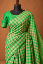 House Of Paramya emerald green Kanchipuram silk saree with a traditional checked pattern and intricate zari border.