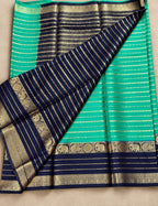 House Of Paramya navy blue and turquoise green crepe silk saree with gold zari elephant and peacock border detail.