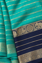 House Of Paramya turquoise green and navy blue crepe silk saree with intricate gold zari elephant and peacock border