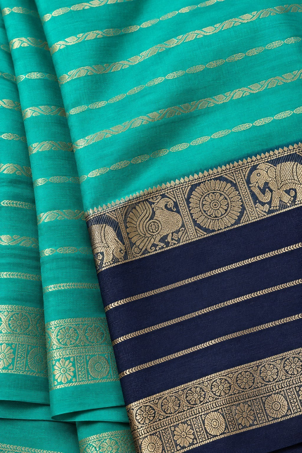 House Of Paramya turquoise green and navy blue crepe silk saree with intricate gold zari elephant and peacock border