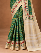 House Of Paramya green silk saree featuring a digital Patola print and a woven cream border with red parrot motifs.