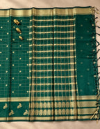 House Of Paramya bottle green raw silk saree with gold checkered weave, floral butis, and ornate zari vine border.