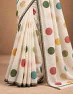House Of Paramya ivory linen cotton saree featuring a multicolor polka dot print and a grey-gold striped border.