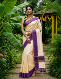 House Of Paramya ivory cotton saree with purple border and gold zari, worn by a woman in a lush garden setting.