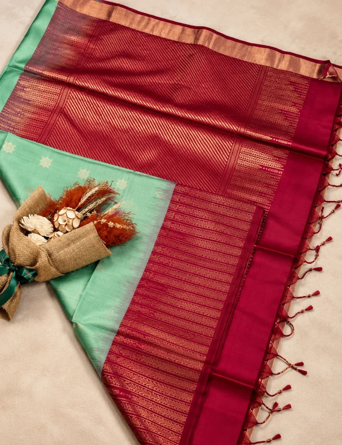 House Of Paramya mint green Kanchipuram silk saree with a rani pink zari border and intricate traditional patterns.