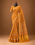 House Of Paramya mustard modal silk saree with white and red Ajrakh block print and a shimmering gold zari border.