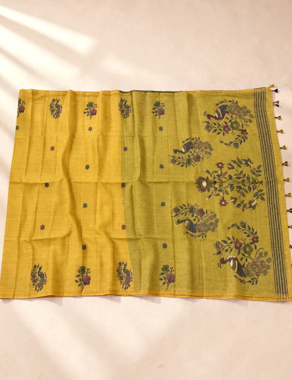 House Of Paramya mustard olive Munga cotton saree featuring woven peacock and floral motifs with a tasseled pallu.
