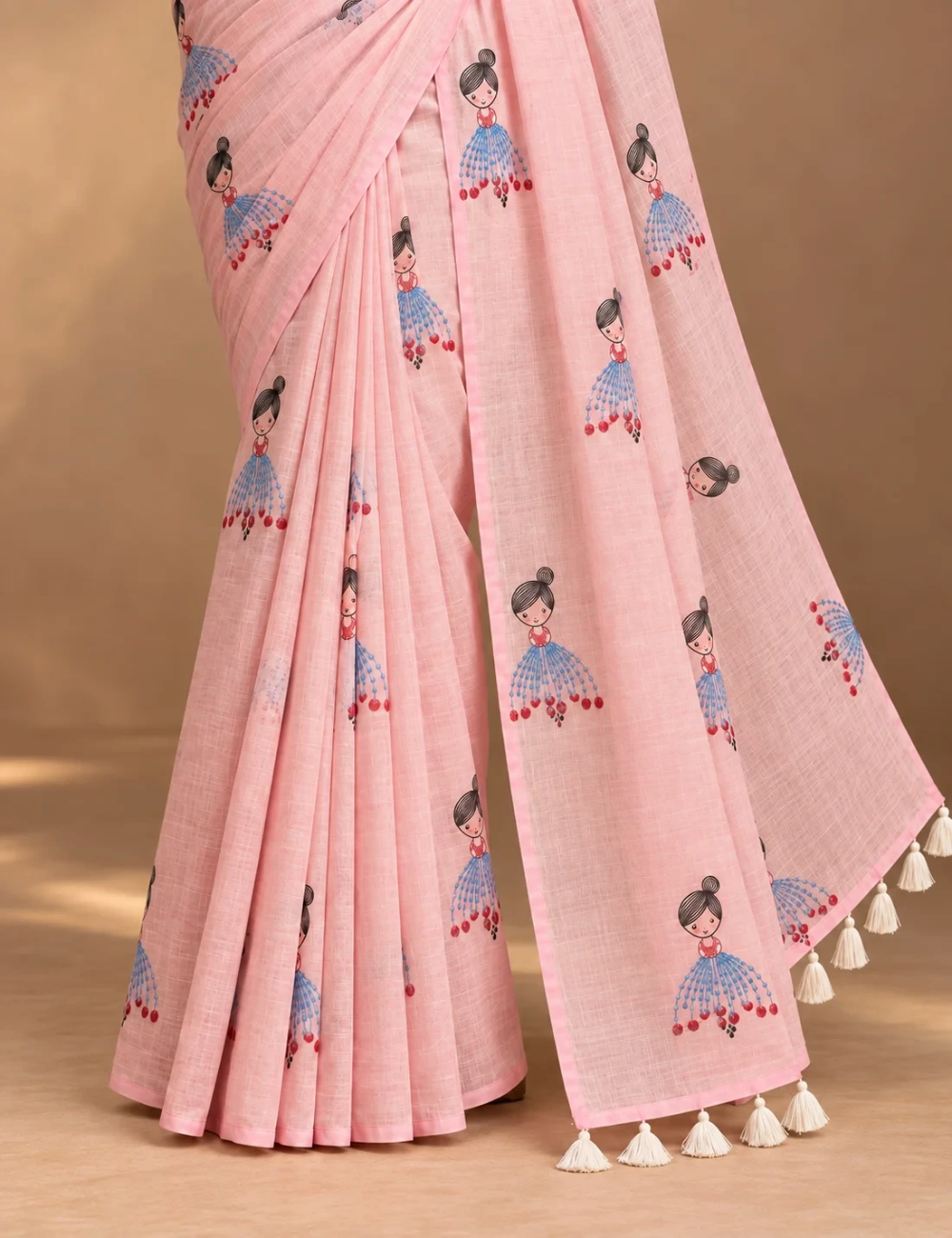 House Of Paramya powder pink linen cotton saree featuring a whimsical doll print and a delicate gold striped border.