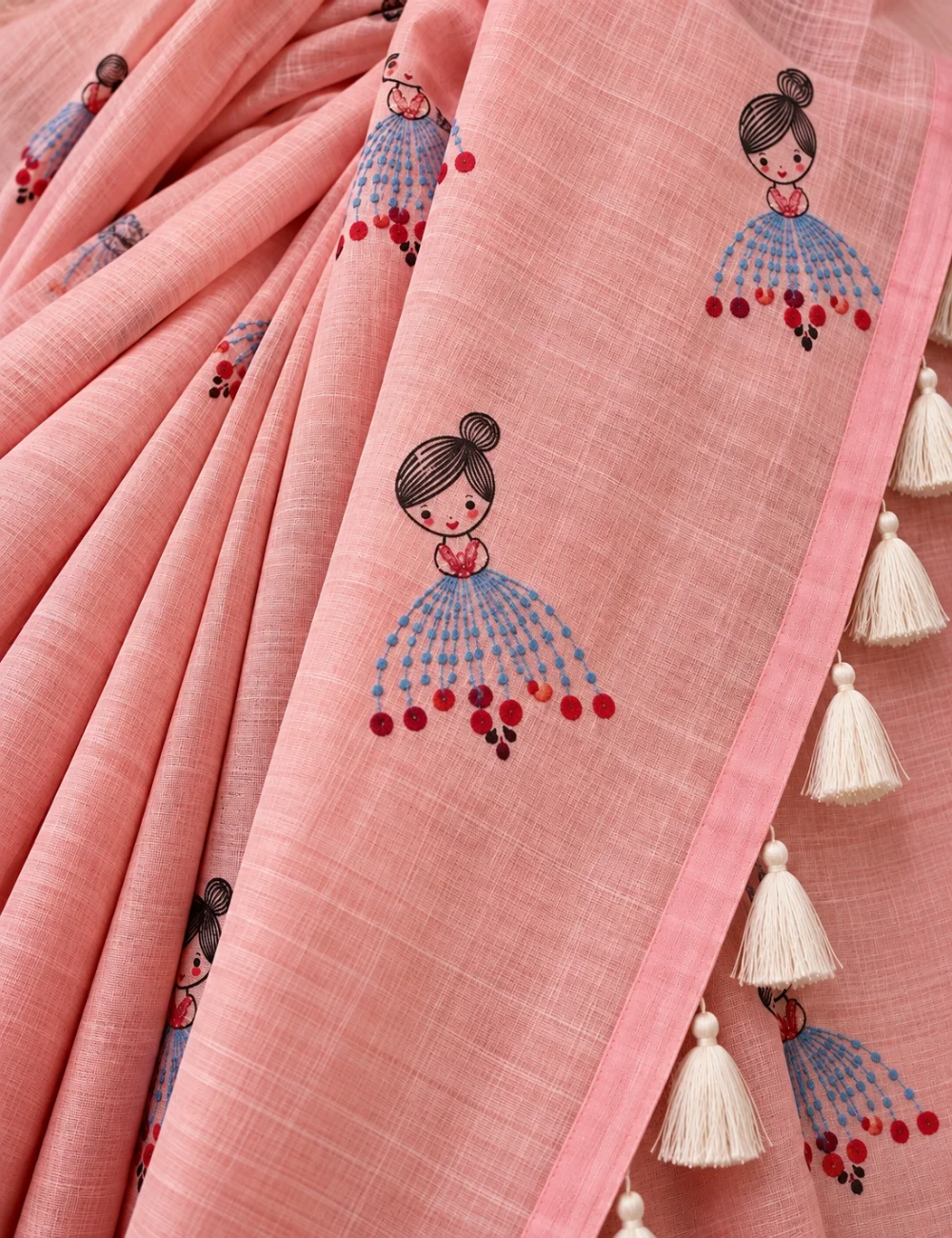 House Of Paramya powder pink linen cotton saree featuring a whimsical doll print and cream tassel border detail.