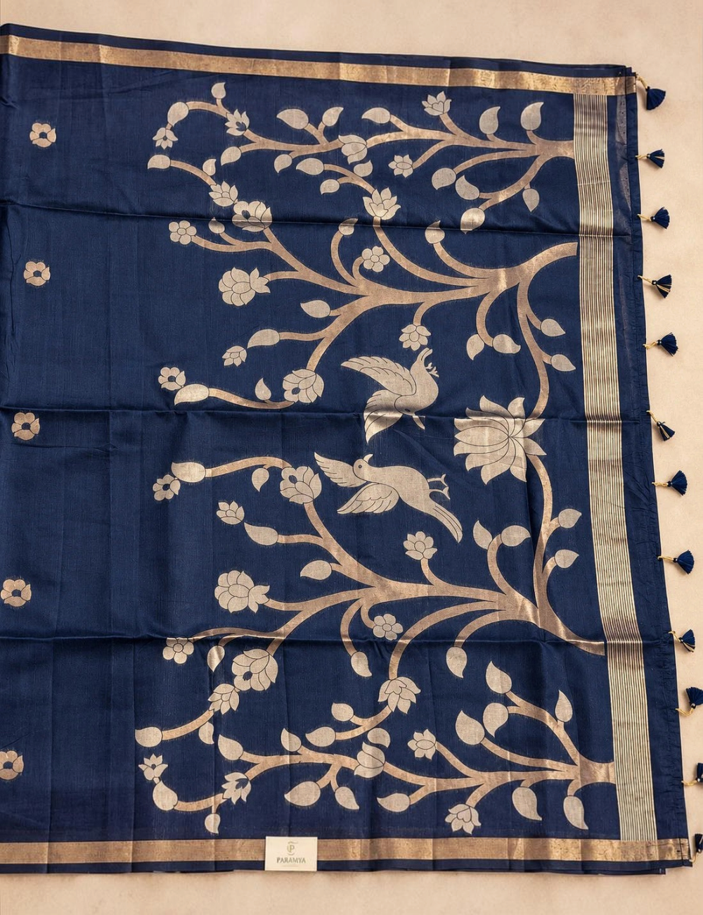 House Of Paramya plum raw tussar cotton saree featuring a gold zari floral tree pallu with bird motifs and tassels.