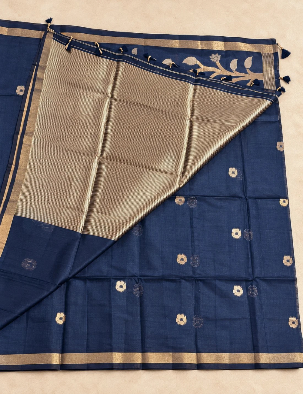 House Of Paramya plum raw tussar cotton saree with gold zari floral pallu, zari buttis, and striped blouse piece.