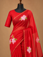 House Of Paramya red linen cotton saree featuring pink floral prints and a delicate gold striped border on a mannequin