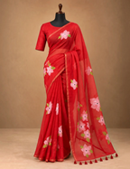 House Of Paramya red linen cotton saree featuring pink floral prints and a gold striped border on a mannequin