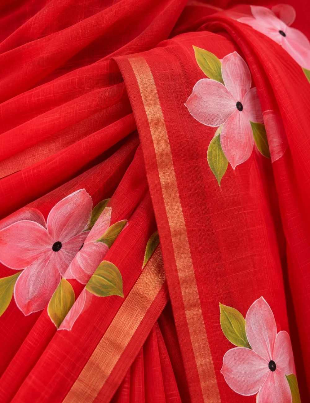 House Of Paramya red linen cotton saree featuring pink floral prints and a shimmering gold striped border