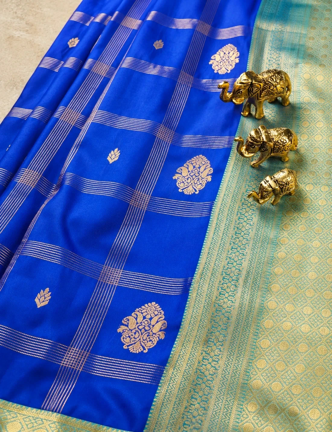 House Of Paramya royal blue semi Kanjivaram silk saree with gold checkered weave, floral butis, and turquoise border