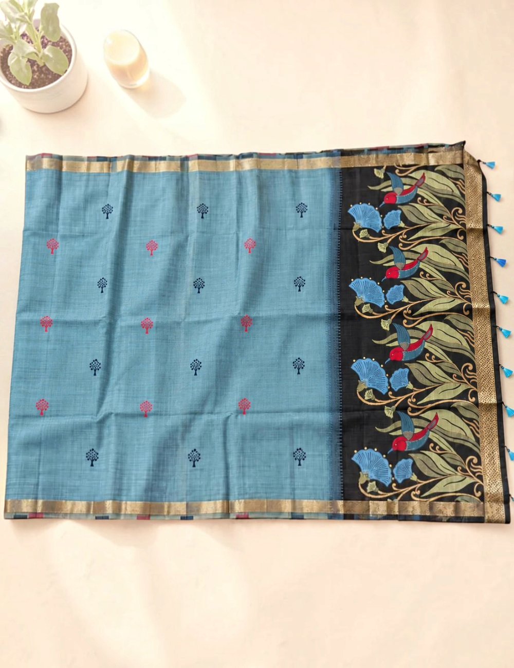 House Of Paramya steel blue Munga cotton saree with tree buttis, charcoal floral pallu, and antique gold zari border.