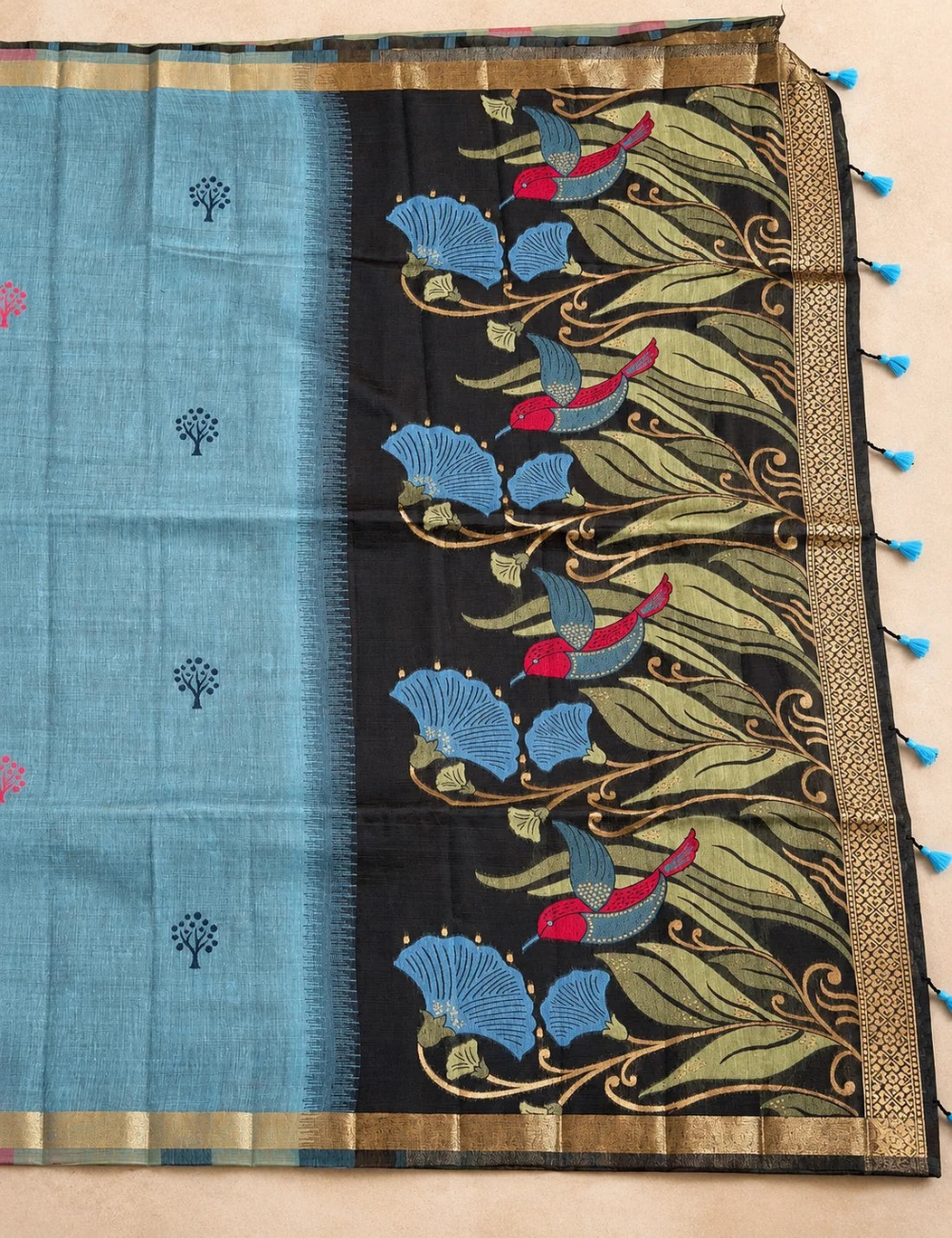House Of Paramya steel blue Munga cotton saree with tree buttis and a charcoal pallu featuring birds and floral motifs.