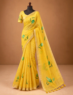 House Of Paramya yellow pure linen saree with green leaf prints, gold border, and tasseled pallu on a mannequin