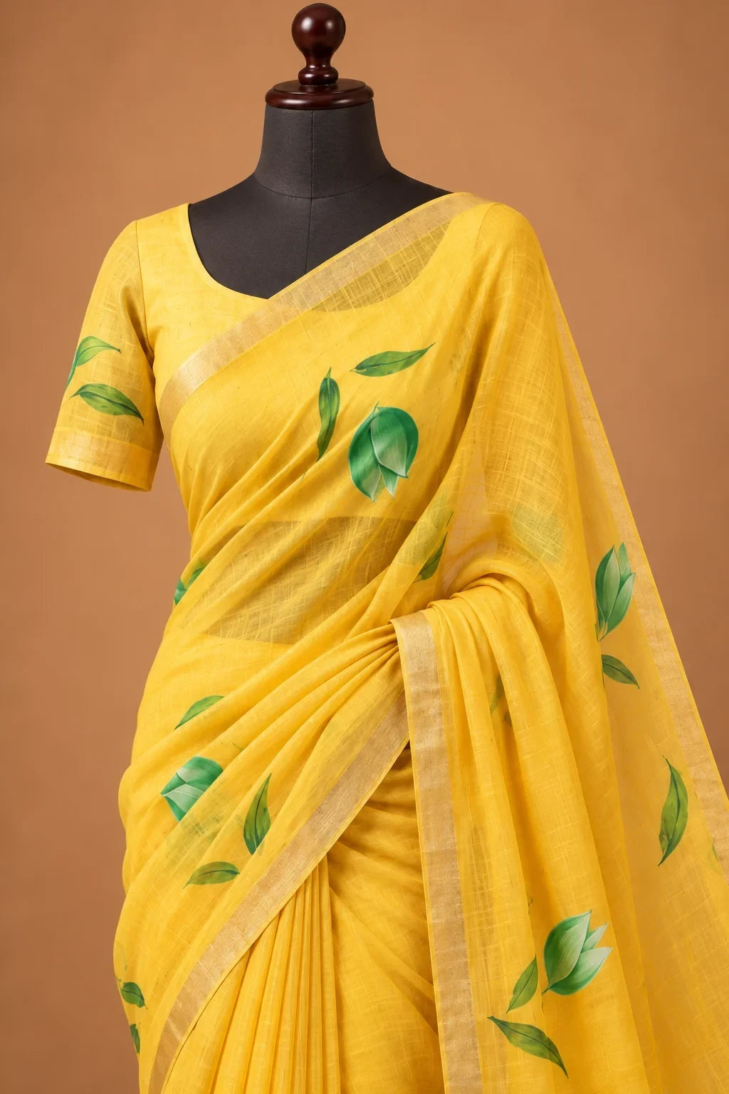 House Of Paramya yellow pure linen saree with green leaf motifs and a subtle gold-toned woven border on a mannequin.